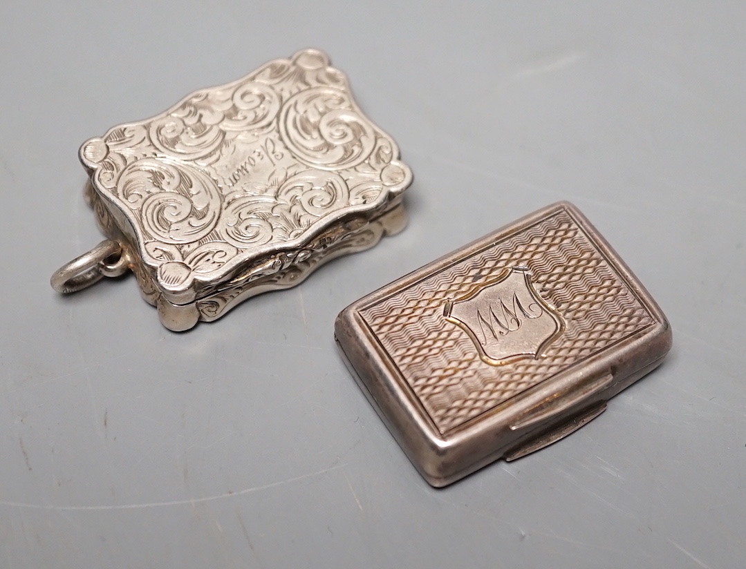 A Victorian engraved silver shaped rectangular vinaigrette, Alfred Taylor, Birmingham, 30mm, 1857 and one other silver vinaigrette by Francis Clark, 30mm, with engraved monogram.